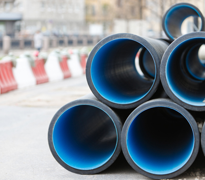 stacked black and blue pipes construction site